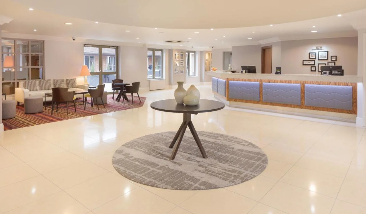 a lobby with a table with vases on it at Cambridge Belfry Hotel & Spa in Cambourne